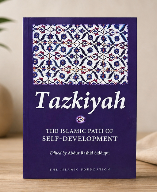 Book titled 'Tazkiyah: The Islamic Path of Self-Development' on a wooden surface with a decorative background.