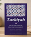Book titled 'Tazkiyah: The Islamic Path of Self-Development' on a wooden surface with a decorative background.